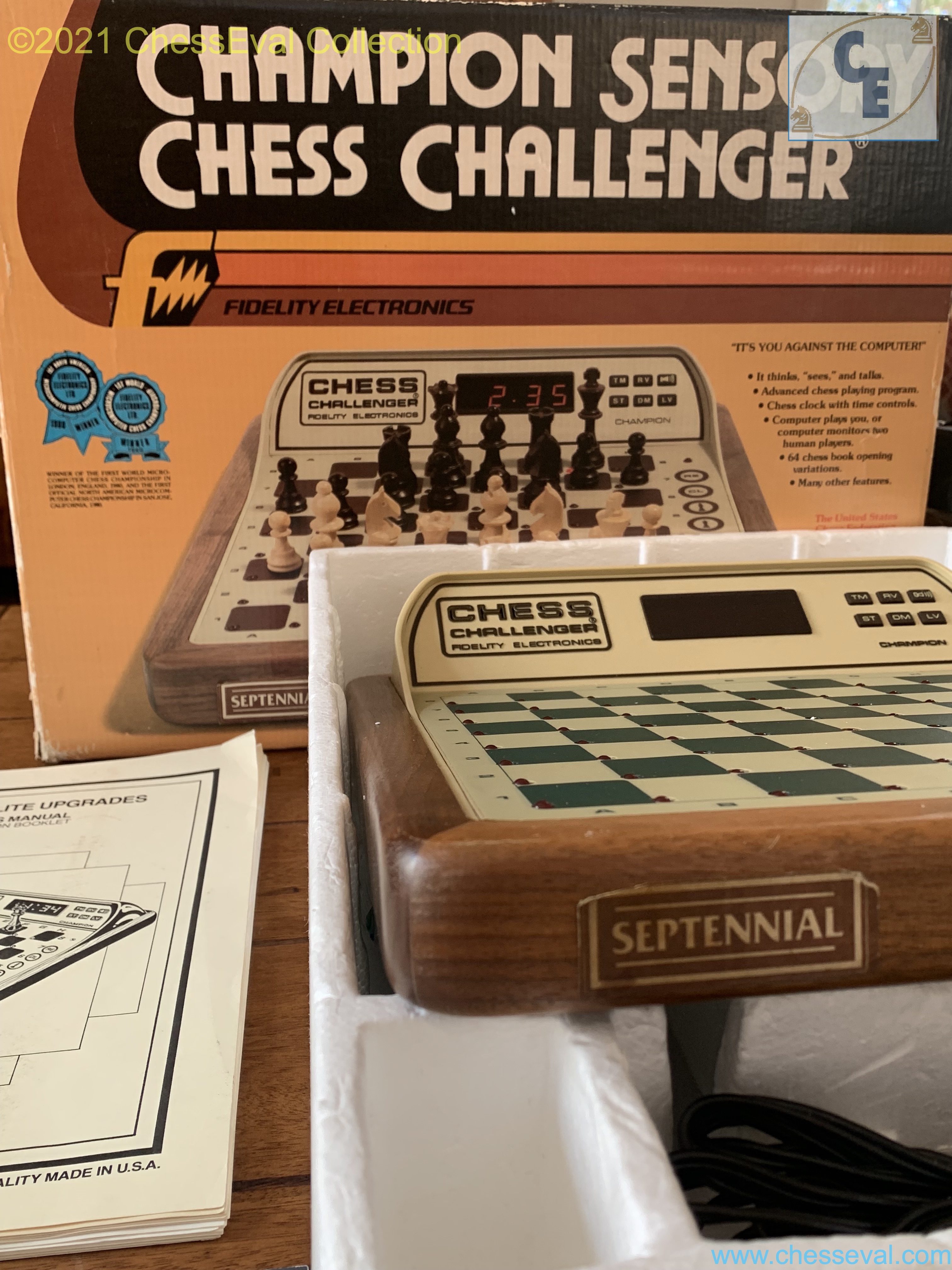 Detail of the Septennial front plaque beside the original box and manuals.